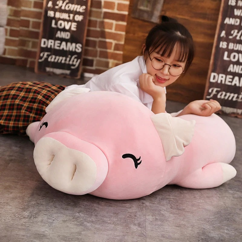 Woman Lying beside a squishy piggy stuffed animal