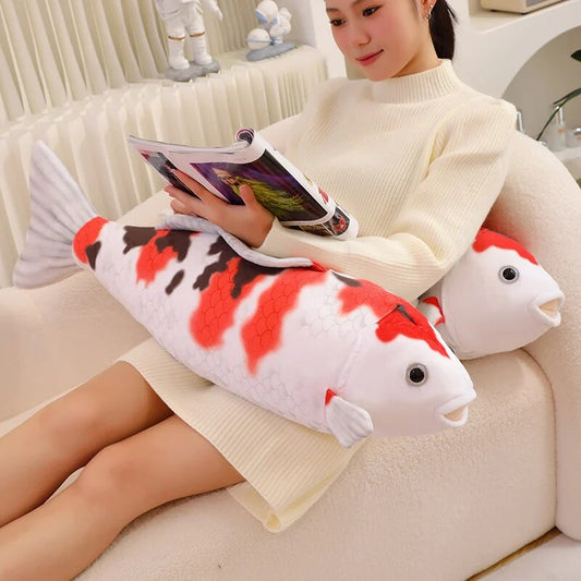 woman reading a magazine beside a koi fish plush
