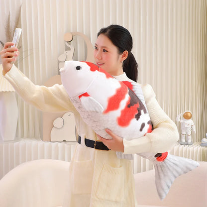 woman taking a selfie with a koi fish plush