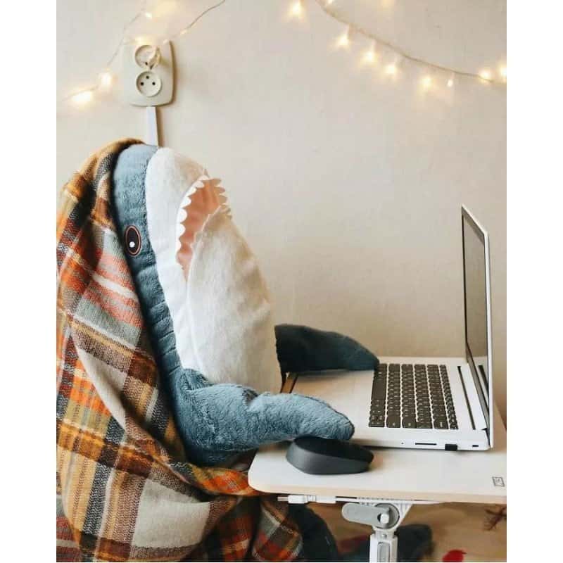 kawaii blue shark plush pillow using a laptop