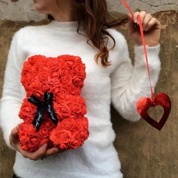 woman holding a red artificial rose teddy bear