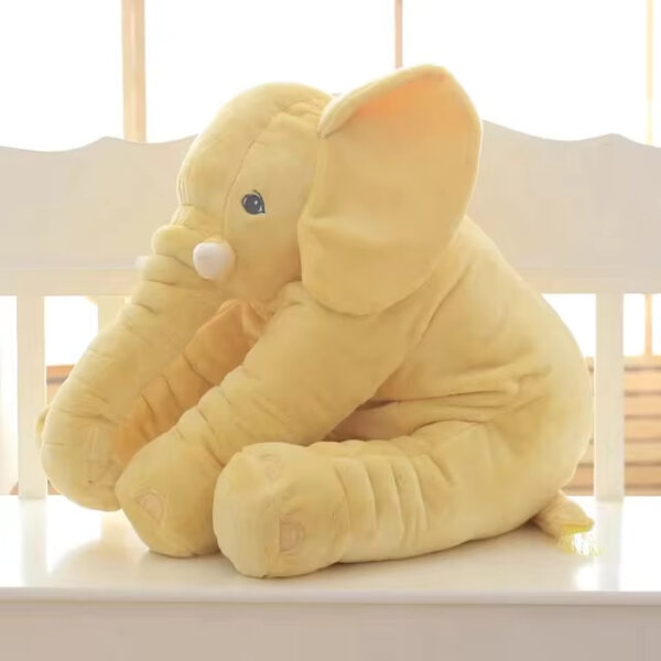 A yellow baby elephant stuffed animal sitting.