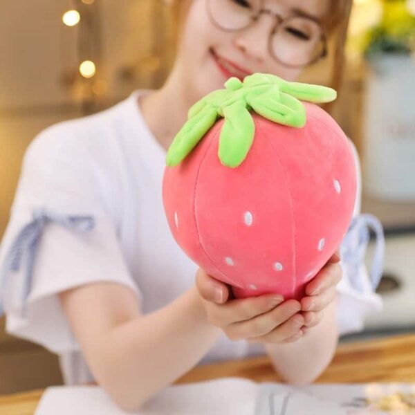Woman holding a kawaii pink strawberry pillow