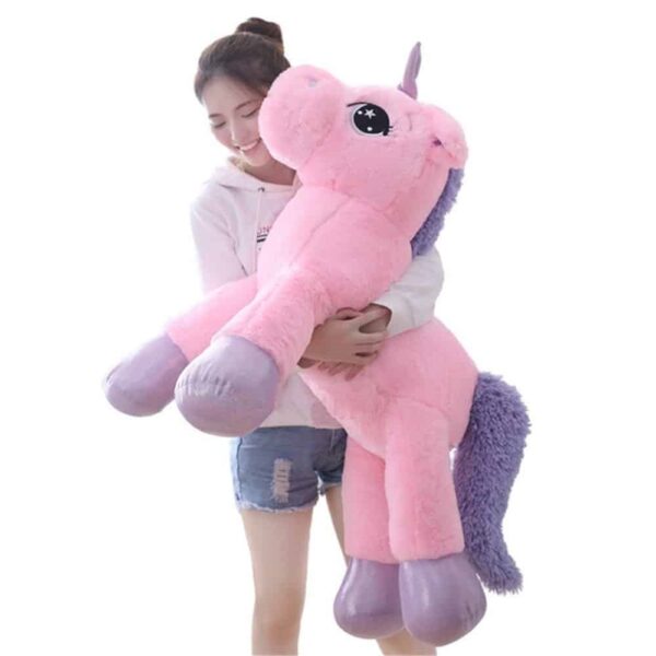 woman holding a giant unicorn plush