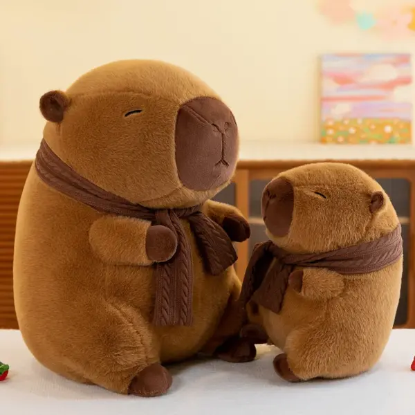 A large and a small brown capybara plush with knitted scarves sitting together, sharing a warm and cozy appearance.