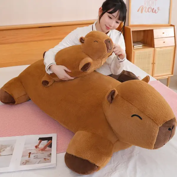A person posing with a giant capybara plush on a bed, emphasizing its large size and comforting presence.