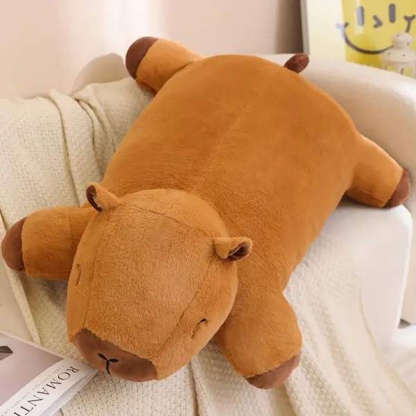 A large, soft giant capybara plush lying on a couch, showcasing its cozy and huggable design.
