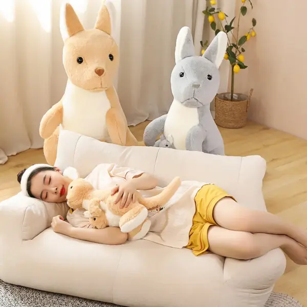 Woman sleeping in a sofa with brown and grey kangaroo plush behind her