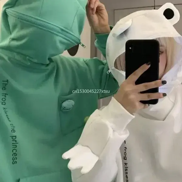 Woman wearing green frog hoodie with 3D eyes and zipped face
